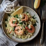 Plated shrimp and cabbage garnished with parsley and lemon.