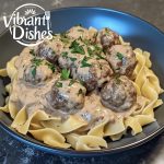 A plate of beef stroganoff with meatballs over egg noodles.