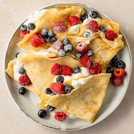 Bisquick crepe recipe featuring light crepes filled with fresh berries and whipped cream.