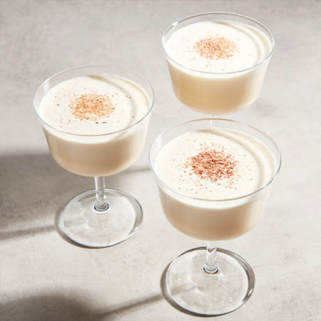 Eggnog recipe featuring creamy eggnog in a glass garnished with whipped cream and nutmeg.