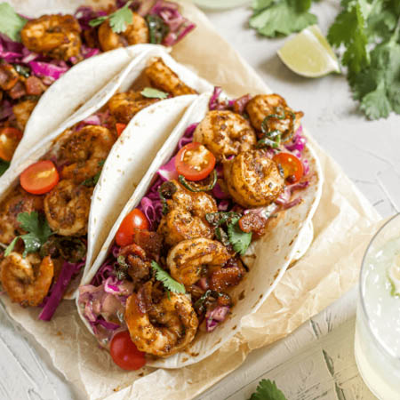 Coleslaw recipe for shrimp tacos featuring shredded cabbage, carrots, and lime dressing on a tortilla.