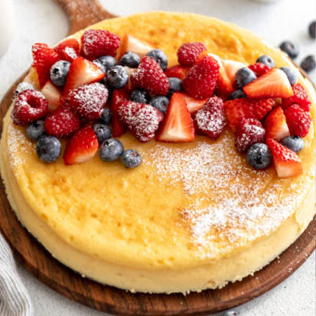 Crustless cheesecake recipe featuring creamy slices topped with fresh berries and mint.