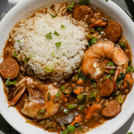 Gumbo greens recipe featuring tender collard greens, smoked sausage, and spices in a hearty bowl.