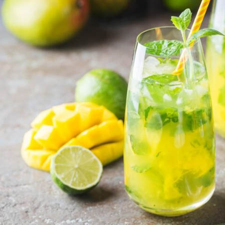 Mango mojito recipe featuring fresh mango, lime, mint, and club soda in a glass.