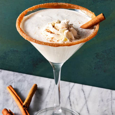 Snickerdoodle martini recipe featuring a creamy drink with cinnamon sugar rim and whipped cream garnish.