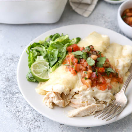 Sour cream enchilada sauce in a bowl, garnished with fresh herbs.