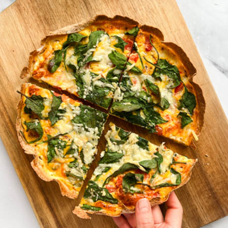 Tortilla quiche bake recipe featuring a baked tortilla crust filled with eggs, cheese, and vegetables.