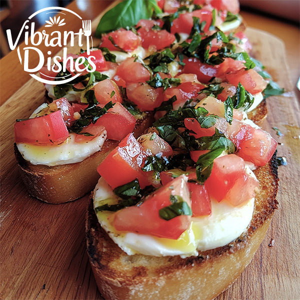 Close-up of Italian bruschetta recipe with mozzarella and tomatoes on a wooden board.